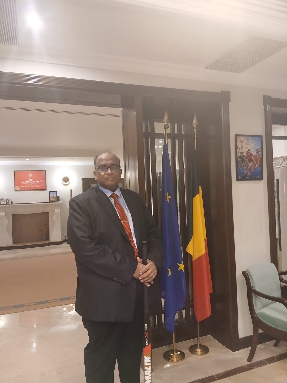 Ghulam Shabbir Babar beside the flags of the European Union and Belgium