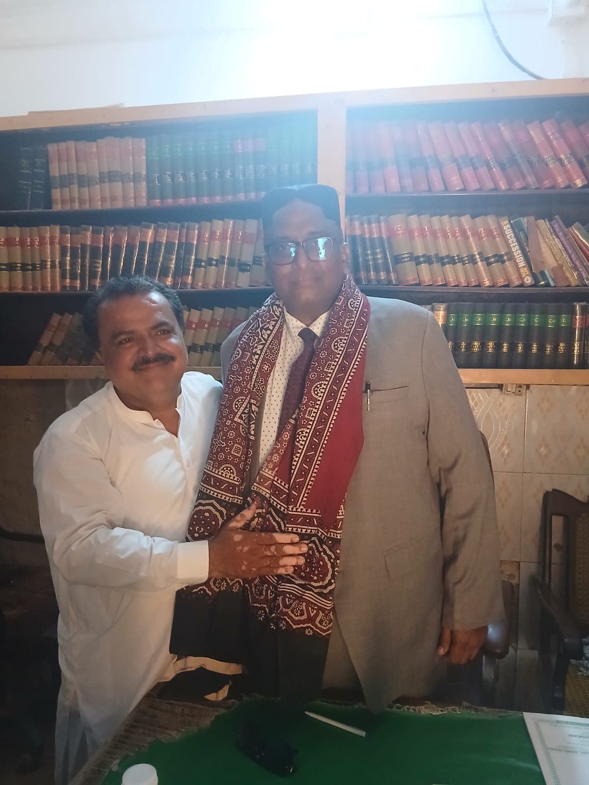 Ghulam Shabbir Babar presented with a Sindhi ajrak in a bar library